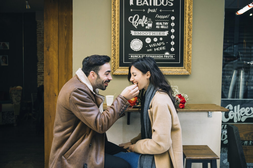 man-feeding-woman-in-outdoor-cafe